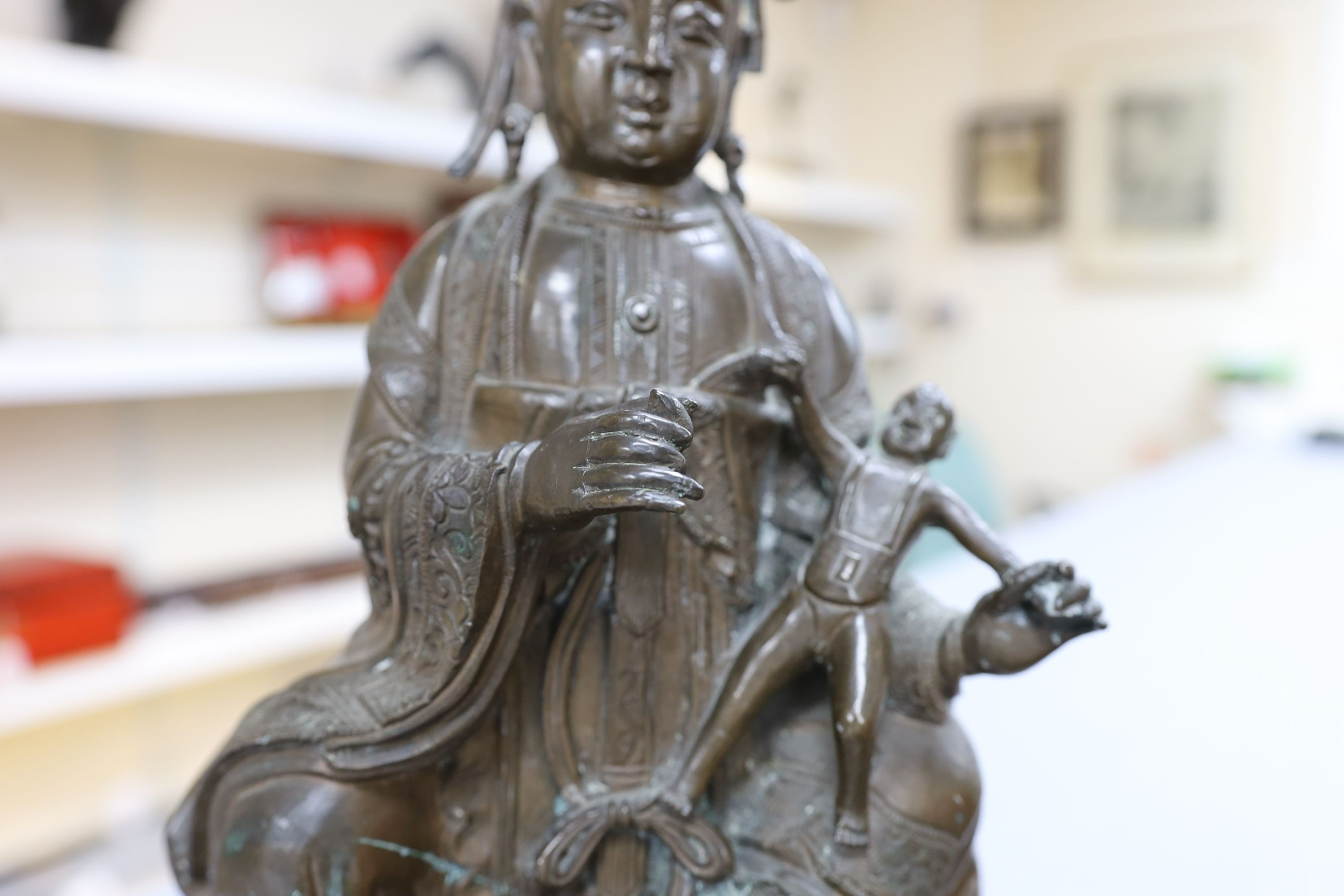 A large Chinese bronze group of Xi Wangmu and a child, late Ming dynasty, 31.5cm high excluding later wood stand